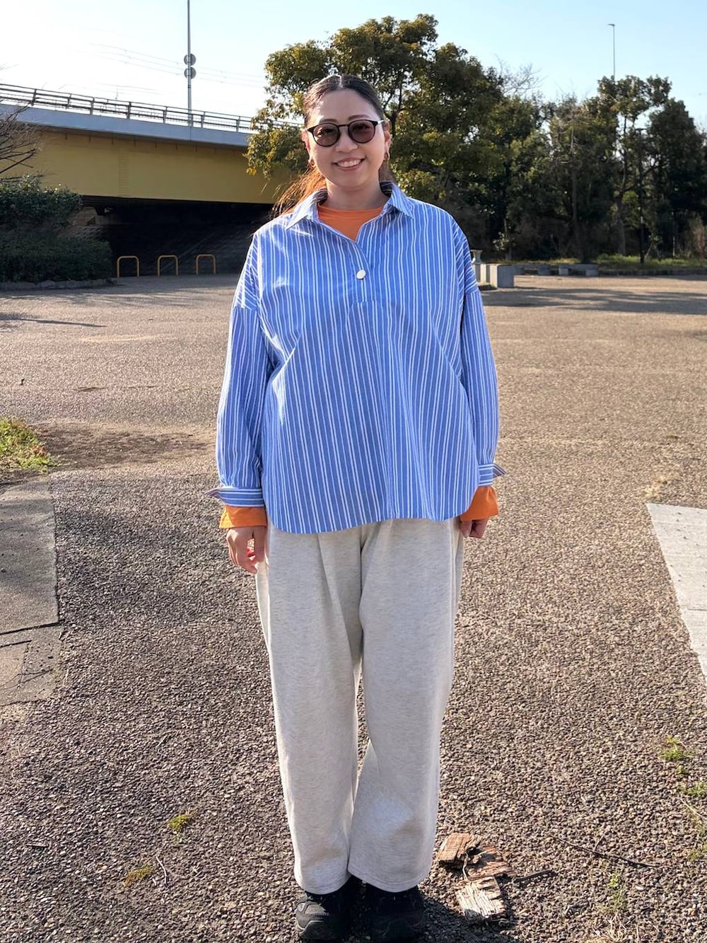 グレー系のスウェットパンツ、ブルー系のシャツ/ブラウス、ベージュ系のピアス（両耳用）を着用したレディースの春コーディネートの2枚目の写真