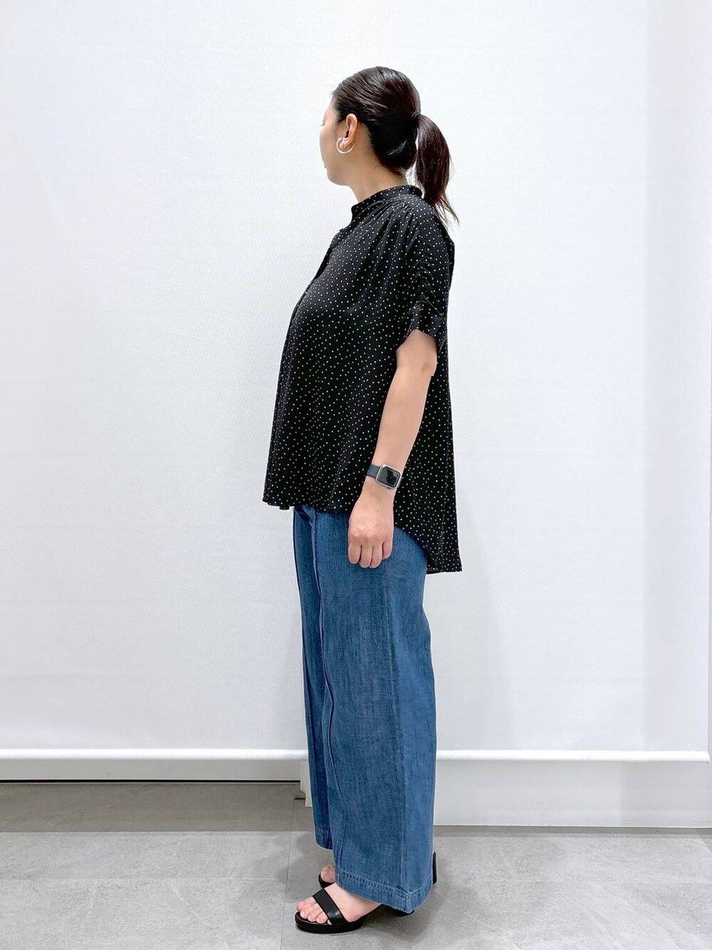 ブルー系のデニムパンツ、ブラック系のシャツ/ブラウス、ブラック系のサンダルを着用したレディースの夏コーディネートの3枚目の写真