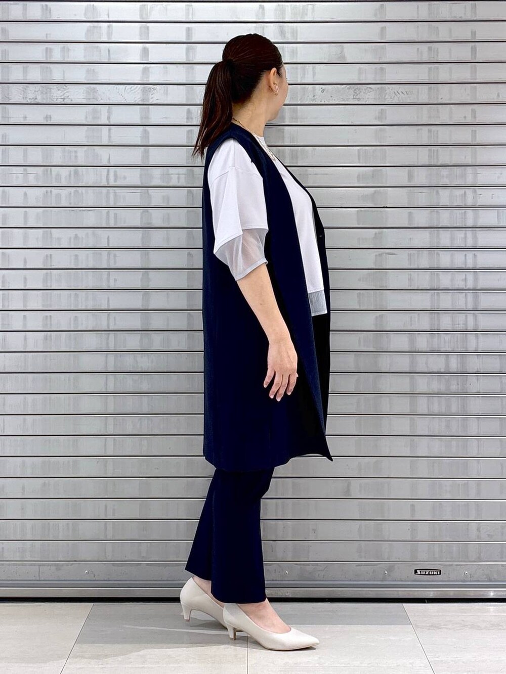 ホワイト系のパンプス、ベージュ系のハンドバッグ、ブルー系のその他パンツを着用したレディースの春コーディネートの5枚目の写真