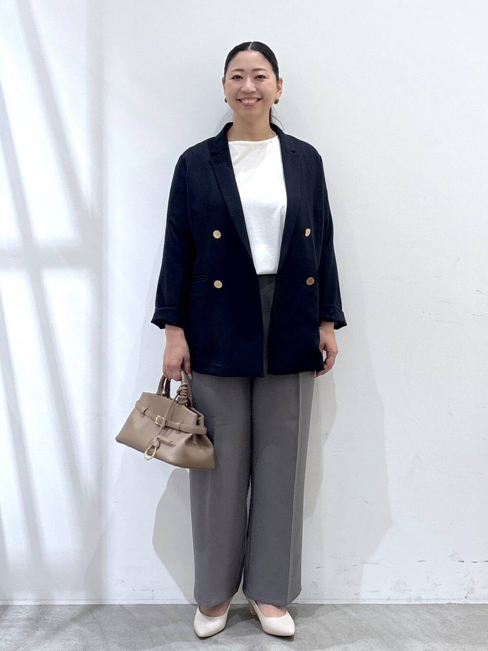 ホワイト系のパンプス、グレー系のその他パンツ、ブルー系のテーラードジャケットを着用したレディースの秋コーディネートの2枚目の写真