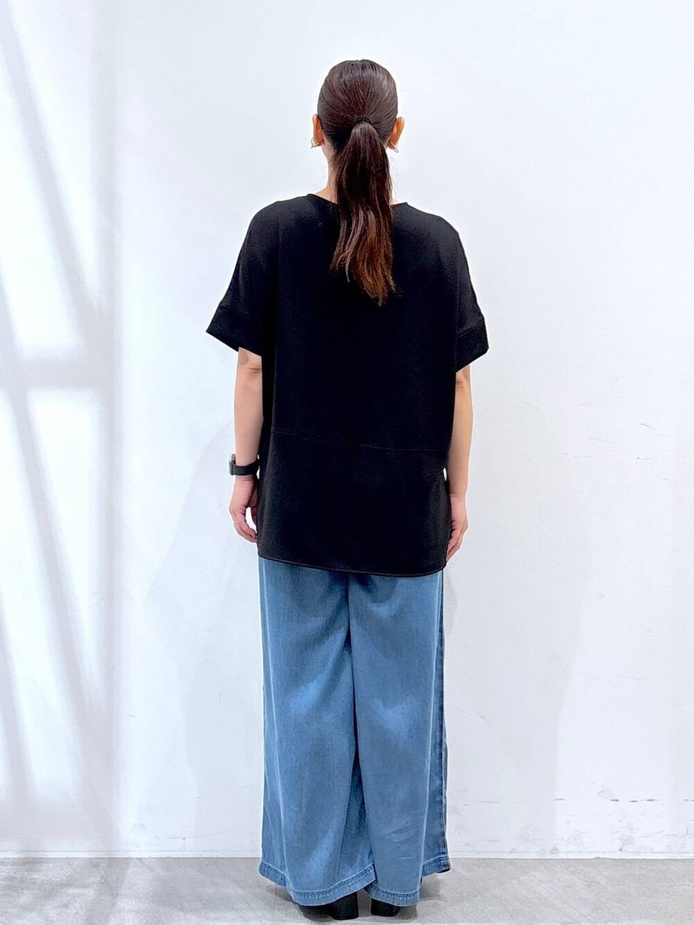 ブラック系のシャツ/ブラウス、ブラック系のサンダル、ブルー系のデニムパンツを着用したレディースの夏コーディネートの4枚目の写真