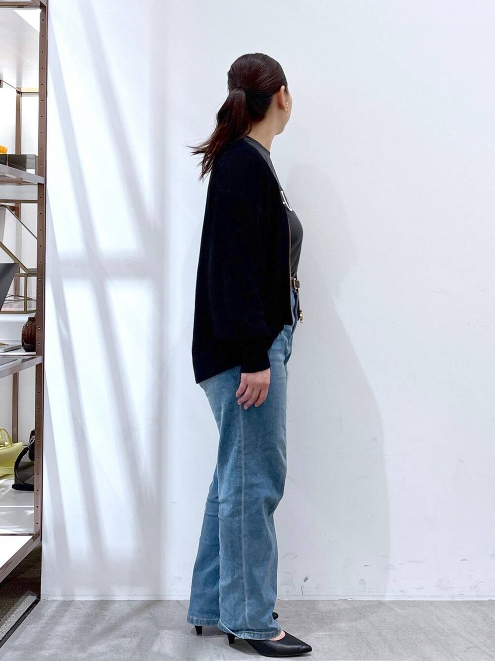 ブルー系のデニムパンツ、ブラック系のカーディガン/ボレロ、グレー系のTシャツ/カットソーを着用したレディースの春コーディネートの5枚目の写真