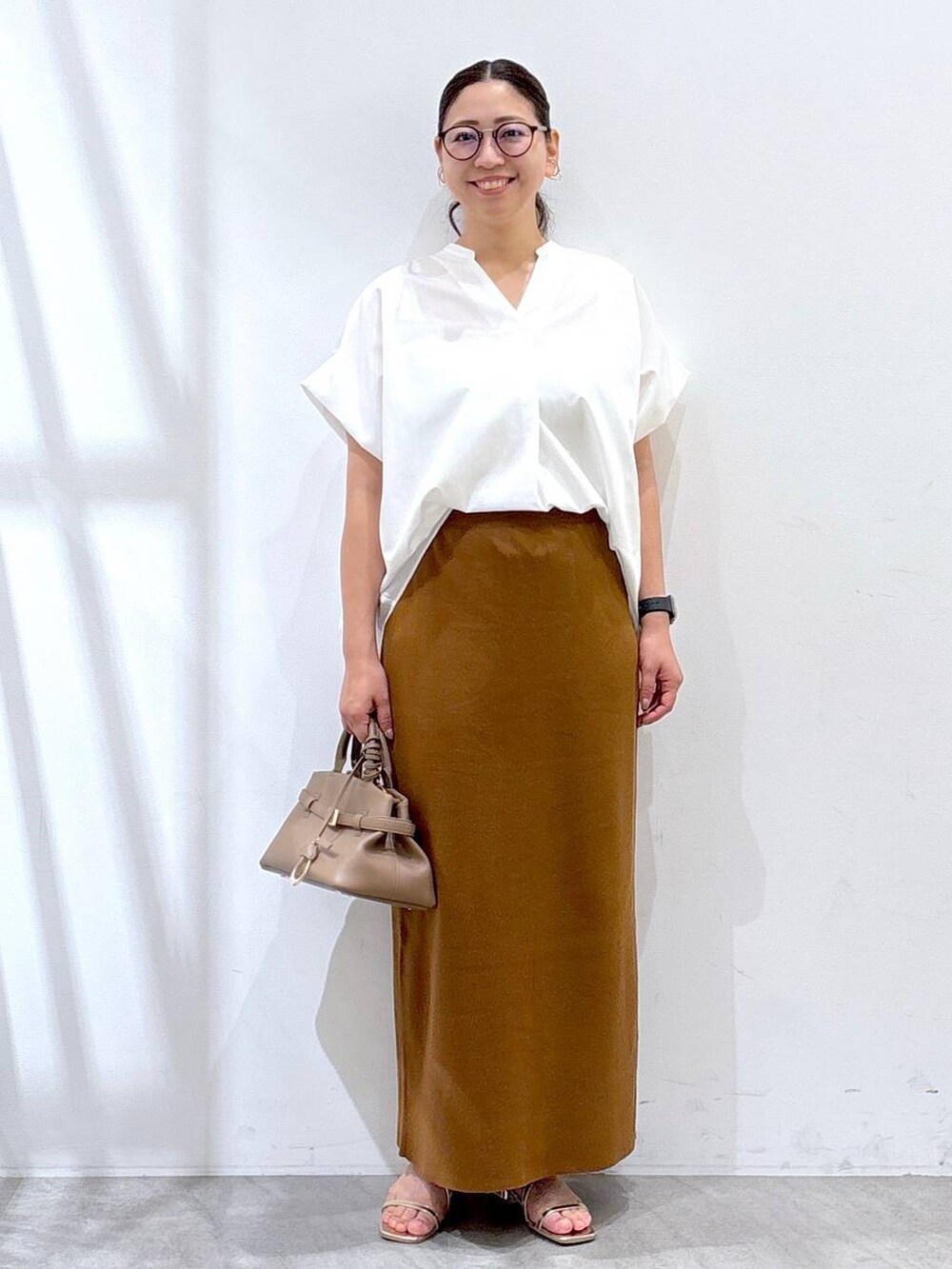 ゴールド系のサンダル、ホワイト系のシャツ/ブラウス、イエロー系のスカートを着用したレディースの夏コーディネートの2枚目の写真