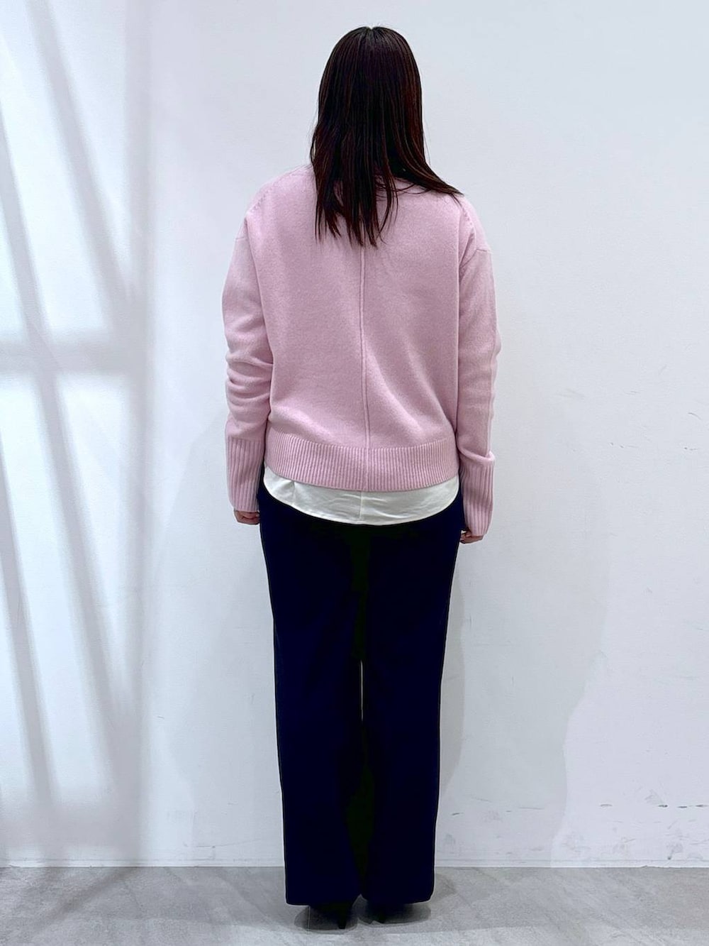 ピンク系のニット/セーター、ホワイト系のシャツ/ブラウス、ブラック系のパンプスを着用したレディースの冬コーディネートの3枚目の写真