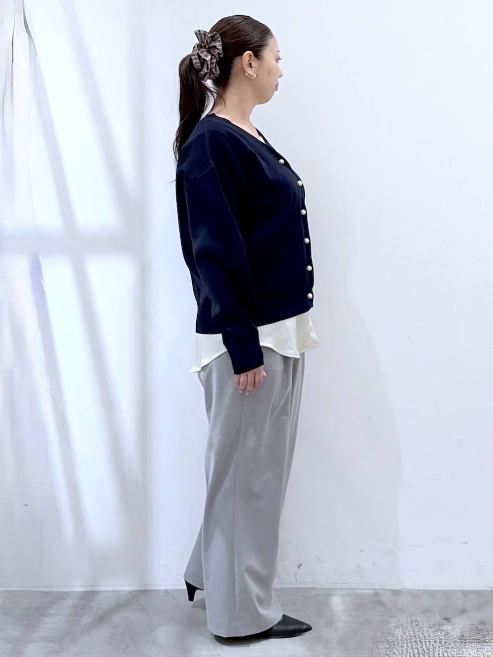 ブラック系のハンドバッグ、グレー系のその他パンツ、ブルー系のカーディガン/ボレロを着用したレディースの春コーディネートの6枚目の写真