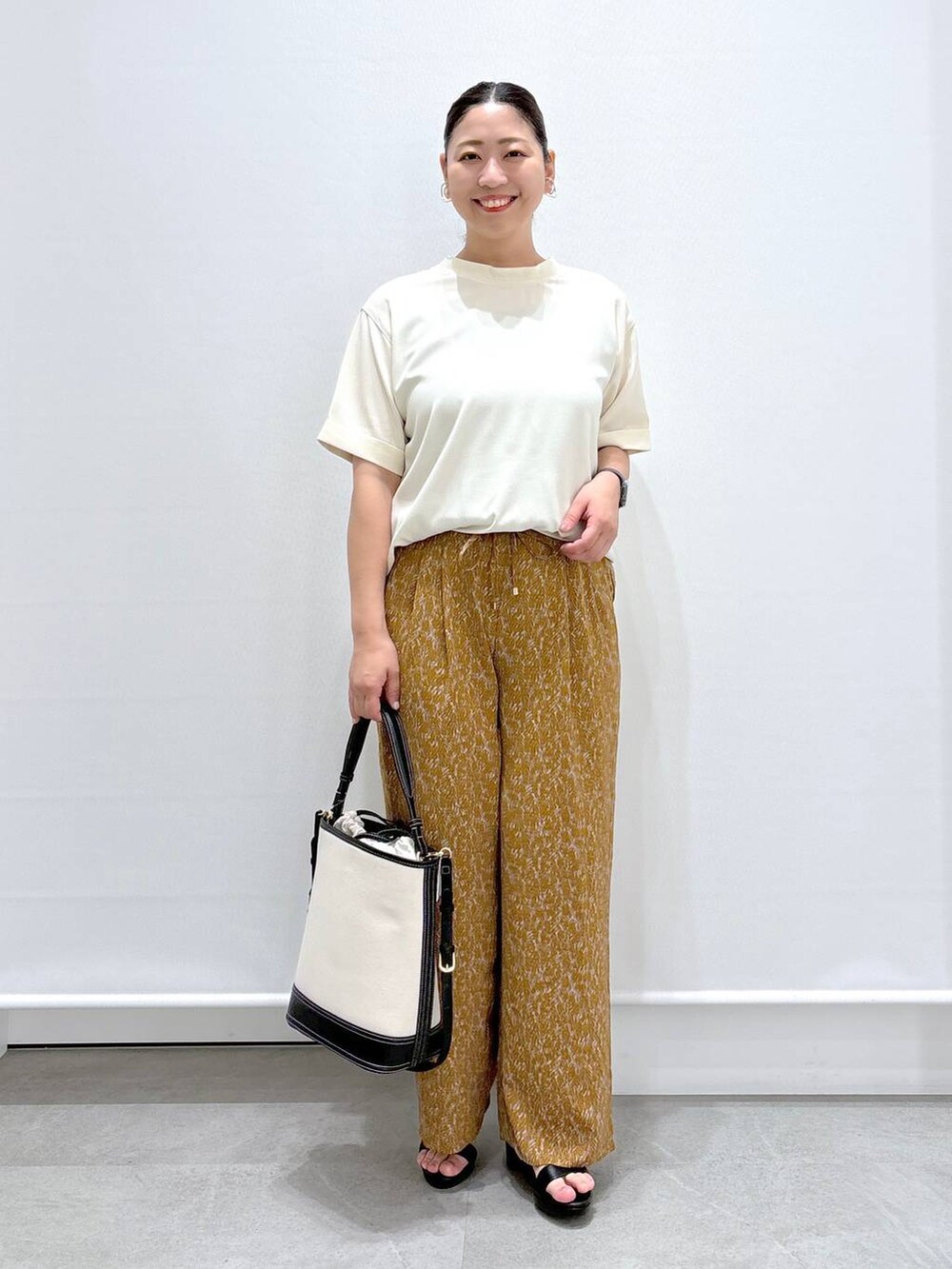 ブラック系のサンダル、ブラウン系のその他パンツ、ホワイト系のシャツ/ブラウスを着用したレディースの夏コーディネートの2枚目の写真