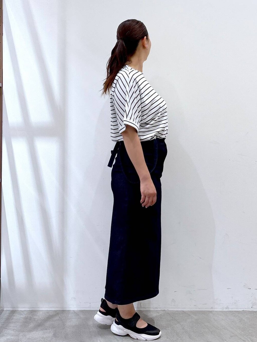 ホワイト系のTシャツ/カットソー、ブラック系のトートバッグ、ブラック系のサンダルを着用したレディースの夏コーディネートの5枚目の写真