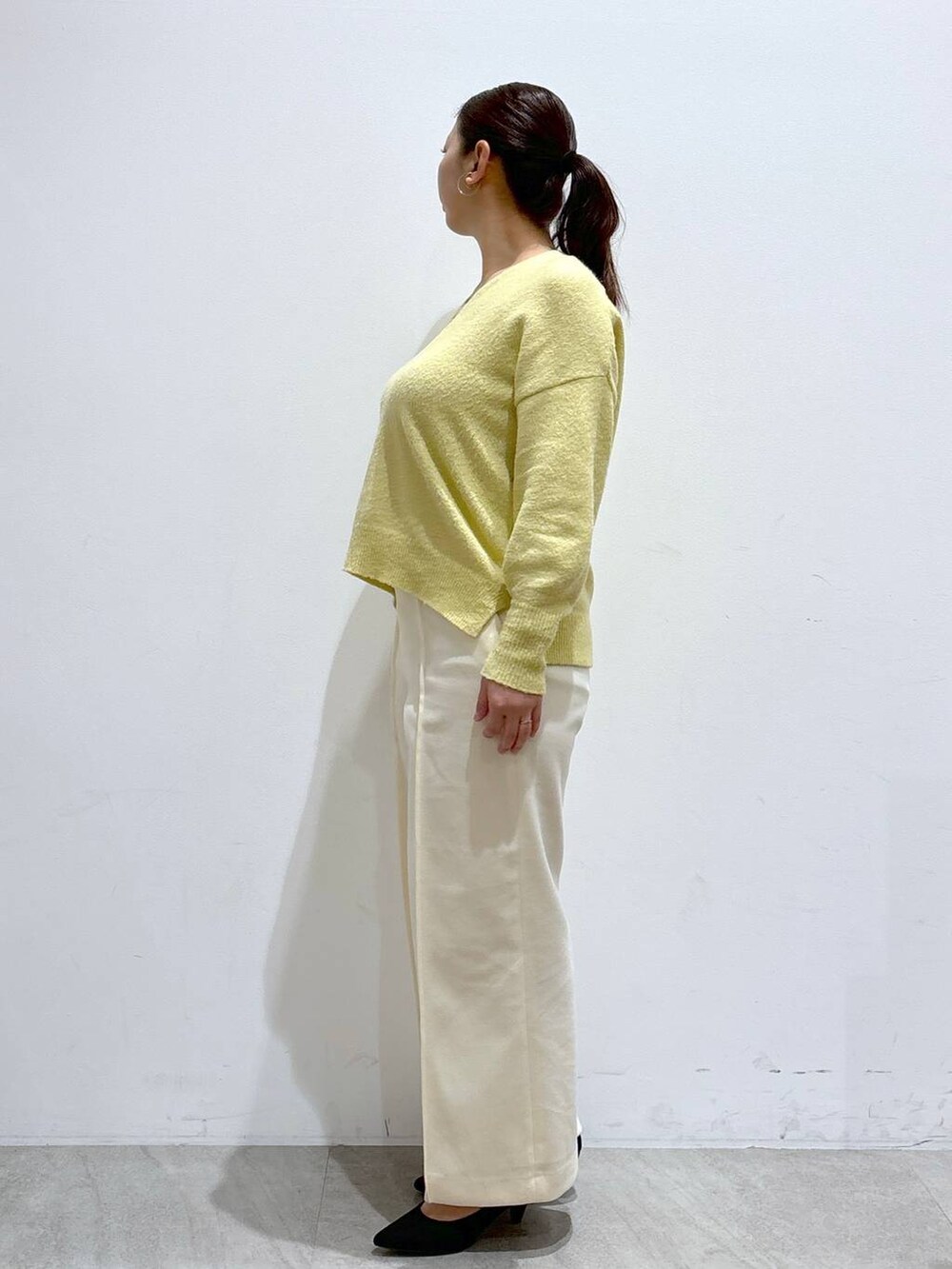 ブラック系のトートバッグ、イエロー系のニット/セーター、ホワイト系のその他パンツを着用したレディースの冬コーディネートの3枚目の写真