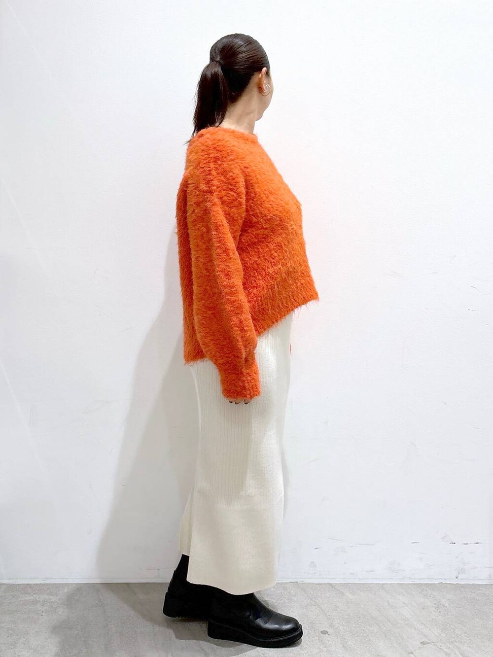 ブラック系のブーツ、ホワイト系のスカート、ホワイト系のスカートを着用したレディースの秋コーディネートの4枚目の写真