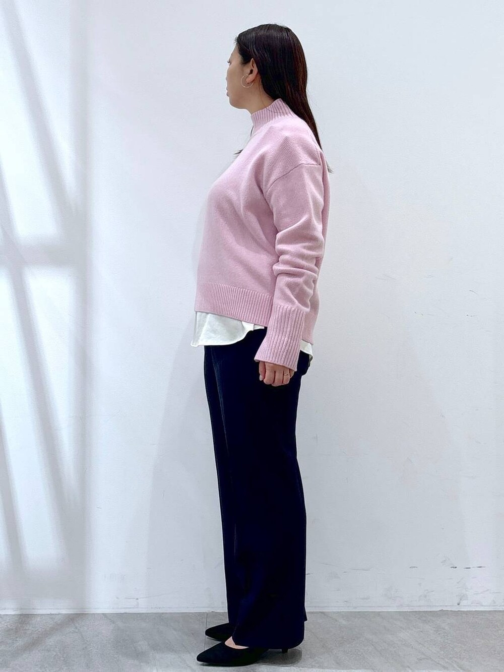 ピンク系のニット/セーター、ホワイト系のシャツ/ブラウス、ブラック系のパンプスを着用したレディースの冬コーディネートの2枚目の写真