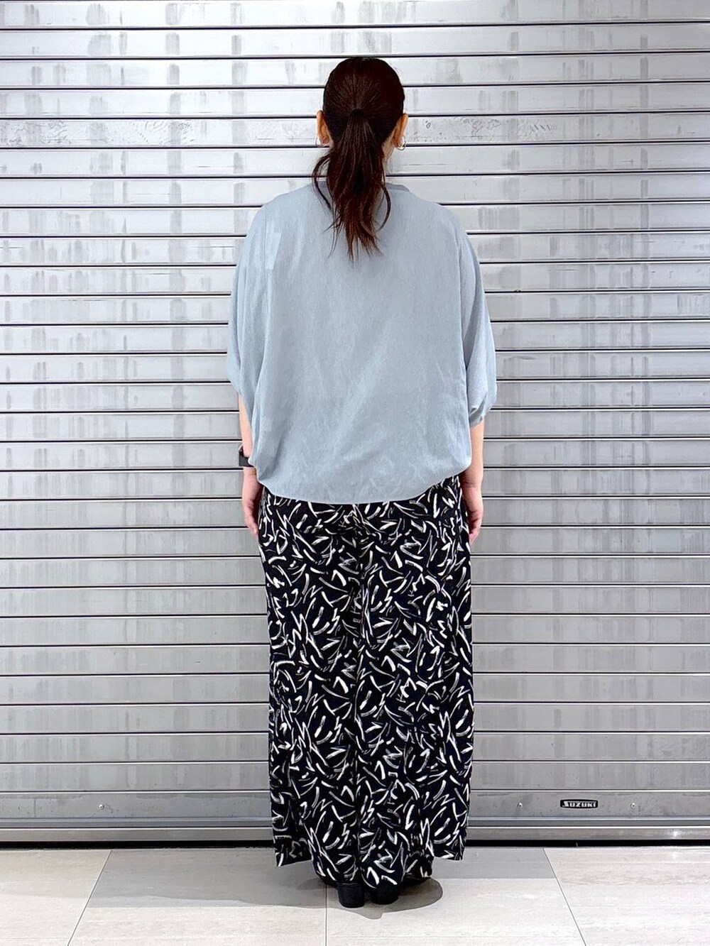 ブラック系のその他パンツ、ブルー系のTシャツ/カットソー、ブラック系のハンドバッグを着用したレディースの春コーディネートの4枚目の写真