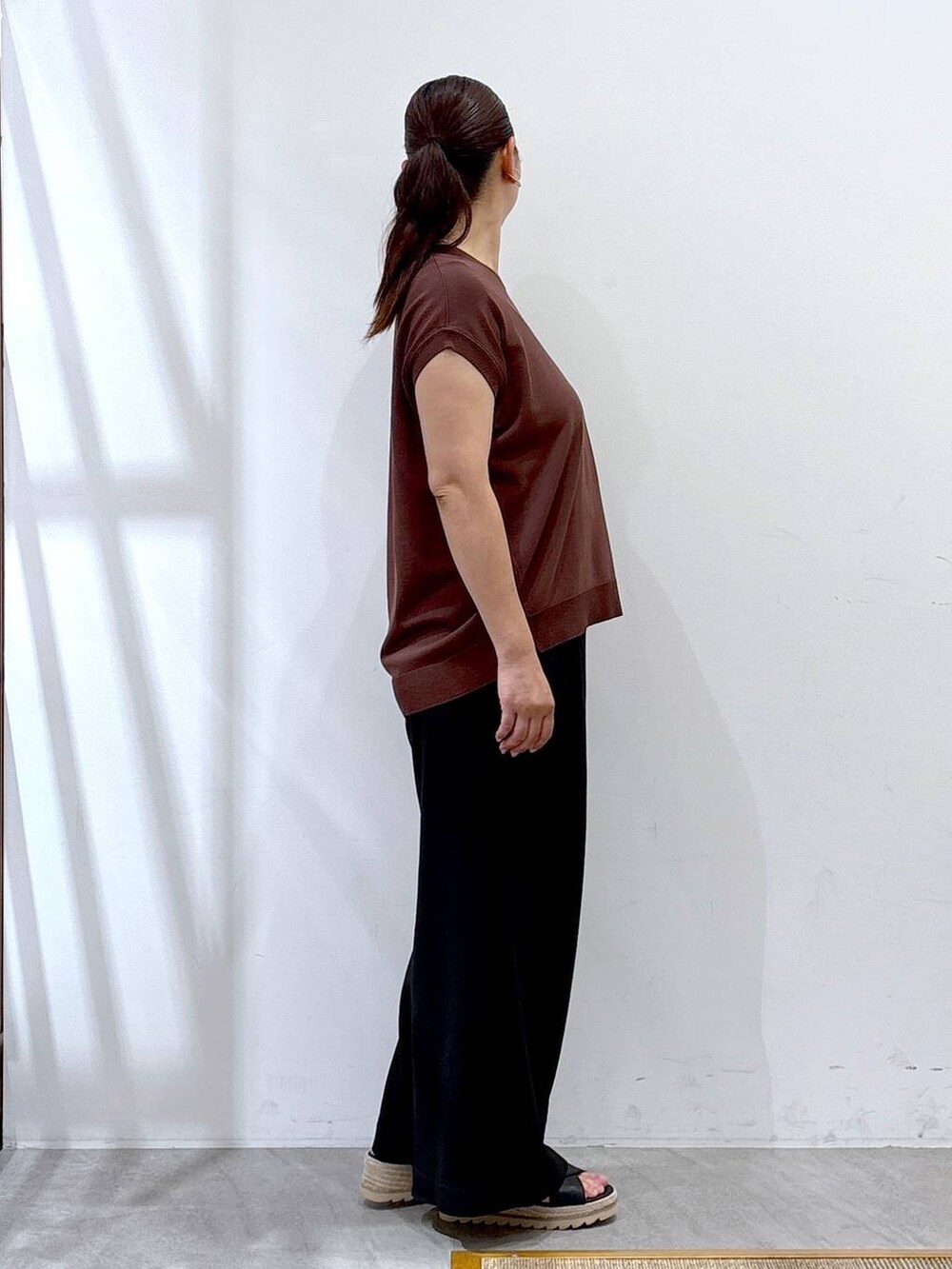 ブラック系のその他パンツ、ブラック系のハンドバッグ、ブラウン系のニット/セーターを着用したレディースの夏コーディネートの5枚目の写真