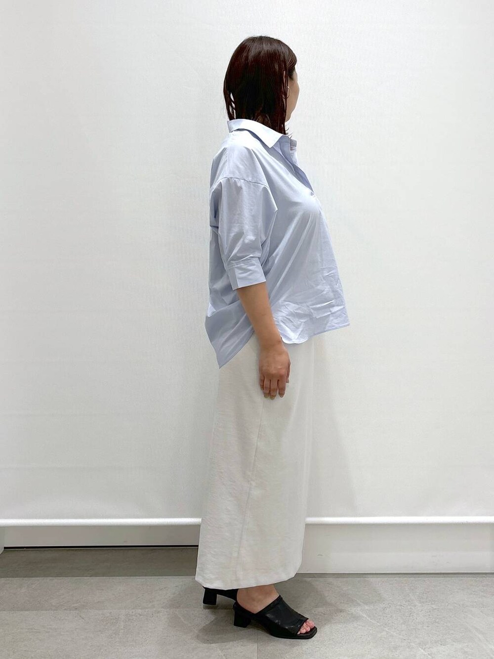 ブラック系のサンダル、ブラック系のハンドバッグ、ブルー系のシャツ/ブラウスを着用したレディースの夏コーディネートの4枚目の写真