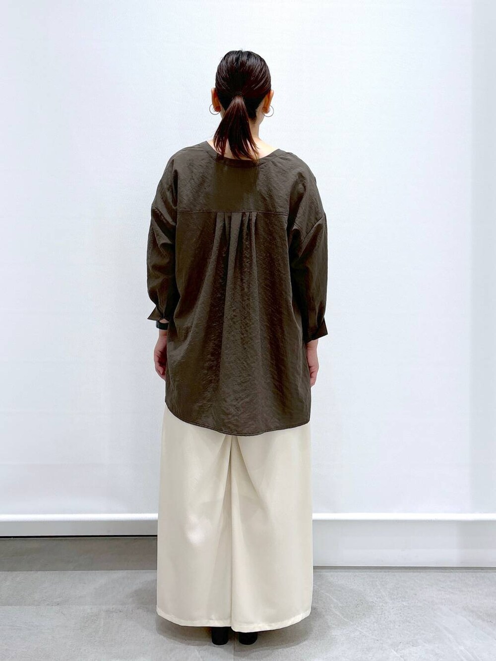 ブラウン系のシャツ/ブラウス、ホワイト系のその他パンツ、ブラック系のハンドバッグを着用したレディースの夏コーディネートの4枚目の写真