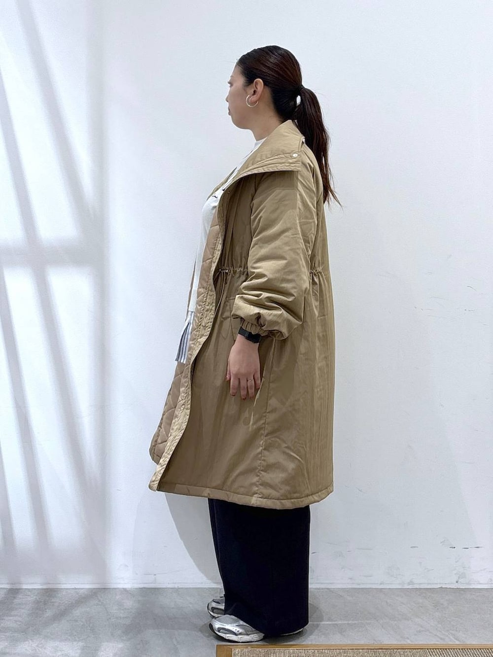 グレー系のスニーカー、イエロー系のダウンジャケット/コート、ベージュ系のTシャツ/カットソーを着用したレディースの秋コーディネートの6枚目の写真