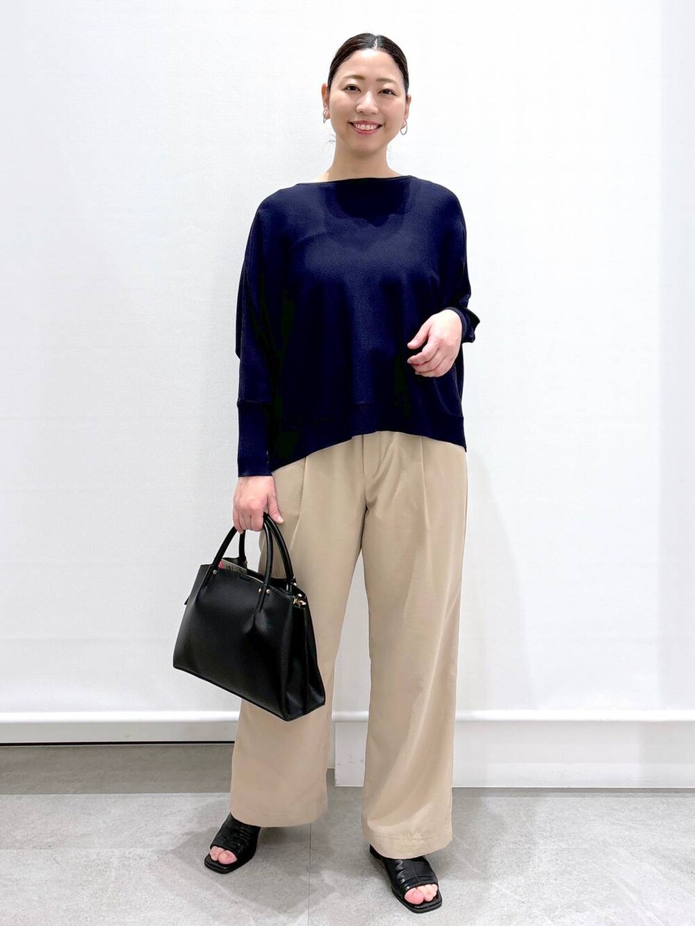 ブラック系のサンダル、ベージュ系のその他パンツ、ブルー系のニット/セーターを着用したレディースの春コーディネートの2枚目の写真