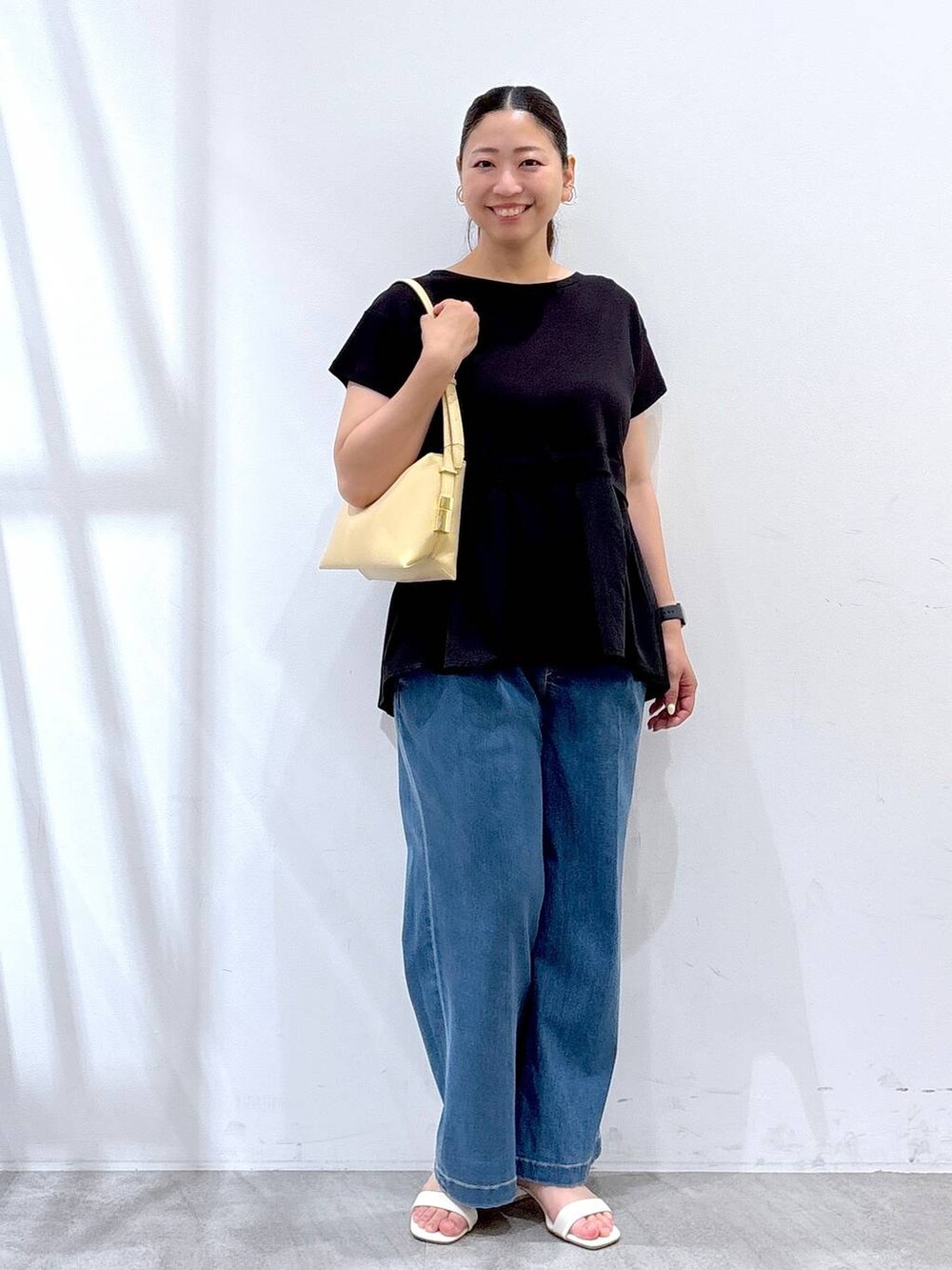 ブラック系のTシャツ/カットソー、ブルー系のデニムパンツを着用したレディースの夏コーディネートの2枚目の写真