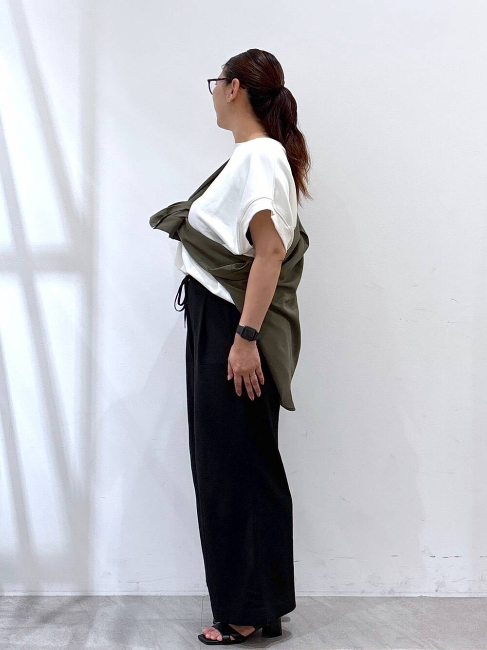 ブラック系のその他パンツ、ブラック系のサンダル、ホワイト系のTシャツ/カットソーを着用したレディースの秋コーディネートの3枚目の写真