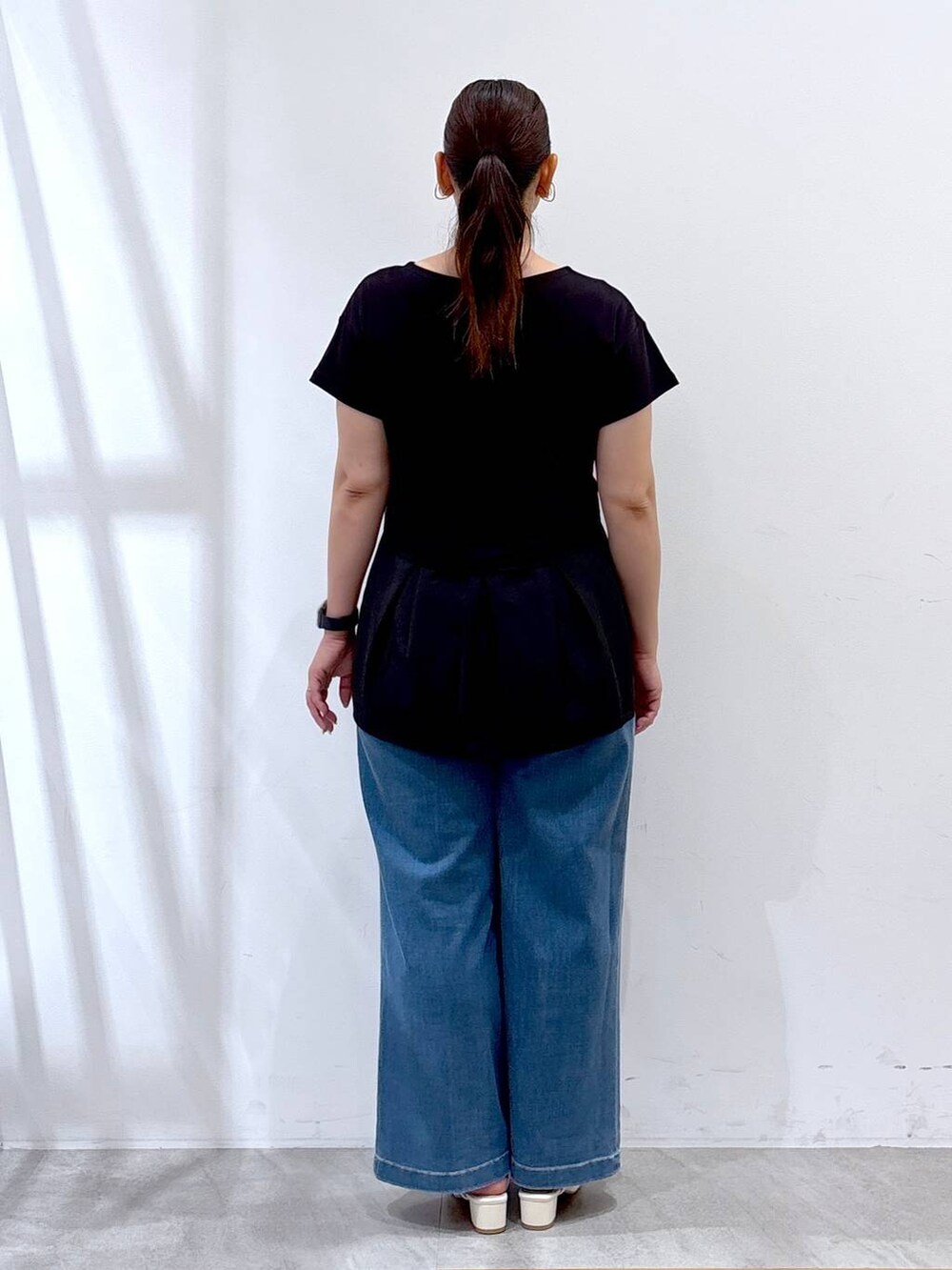 ブラック系のTシャツ/カットソー、ブルー系のデニムパンツを着用したレディースの夏コーディネートの4枚目の写真