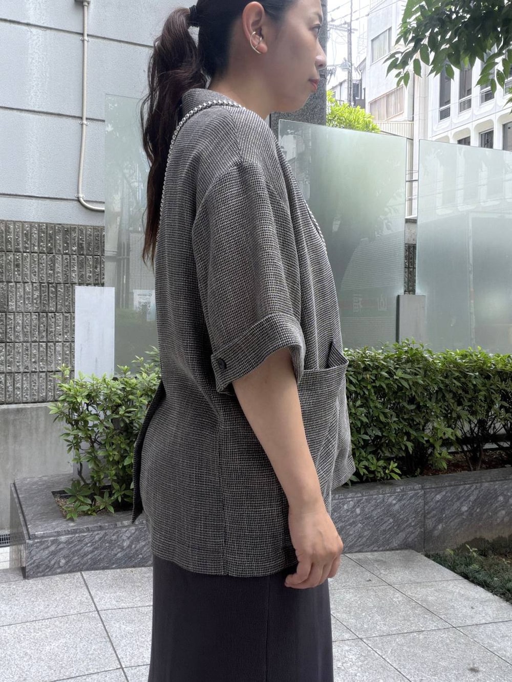 ブラック系のテーラードジャケット、グレー系のワンピース、その他のスマホグッズを着用したレディースの夏コーディネートの4枚目の写真