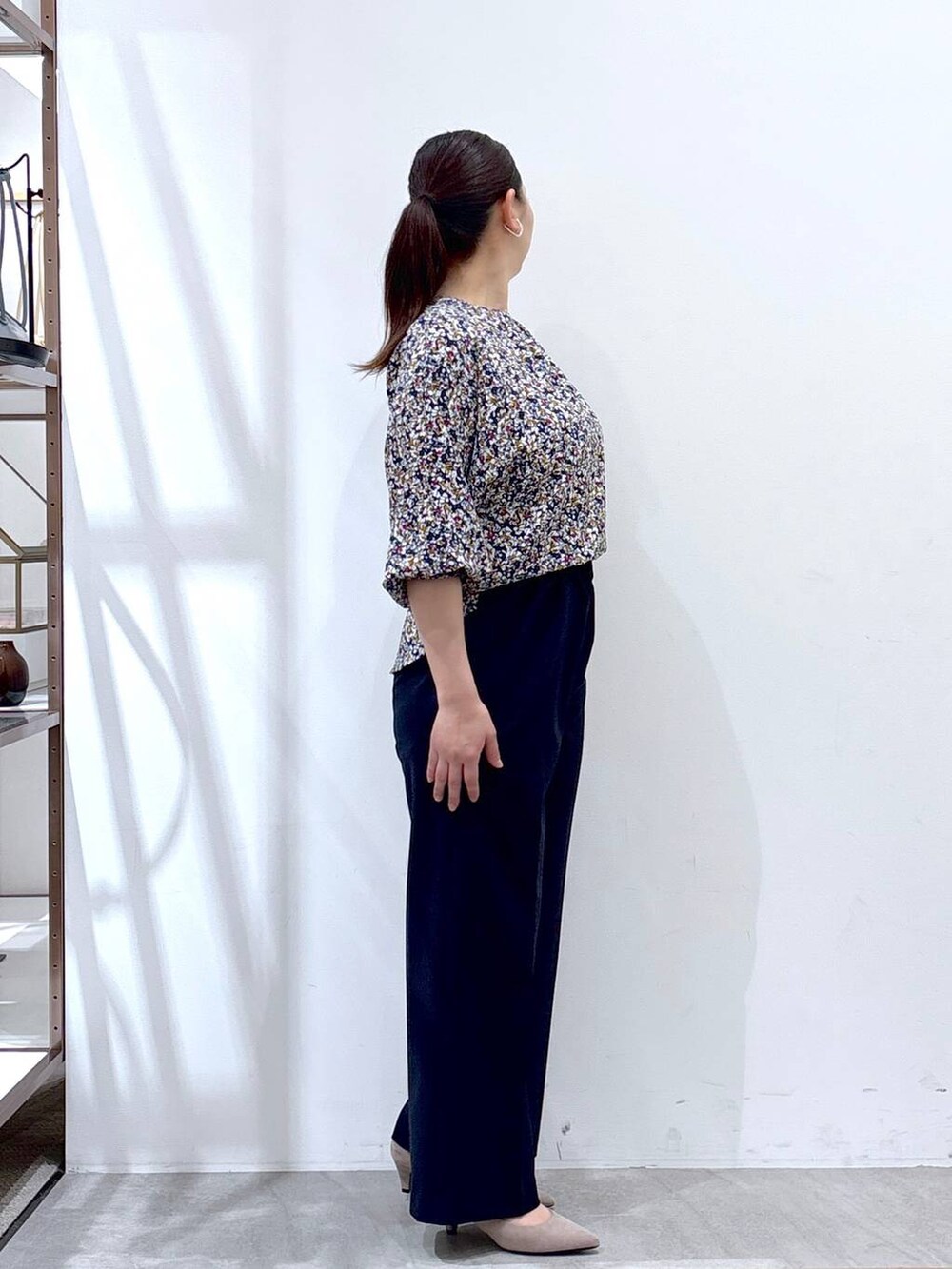 ベージュ系のパンプス、ベージュ系のハンドバッグ、ブルー系のノーカラージャケットを着用したレディースの春コーディネートの5枚目の写真