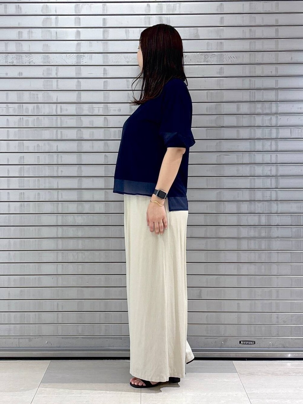 ブラック系のハンドバッグ、ブルー系のTシャツ/カットソー、ベージュ系のその他パンツを着用したレディースの春コーディネートの3枚目の写真