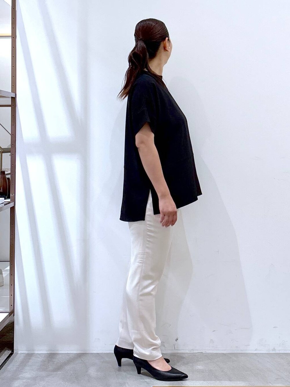 ブラック系のパンプス、ホワイト系のその他パンツ、ブラック系のハンドバッグを着用したレディースの夏コーディネートの4枚目の写真