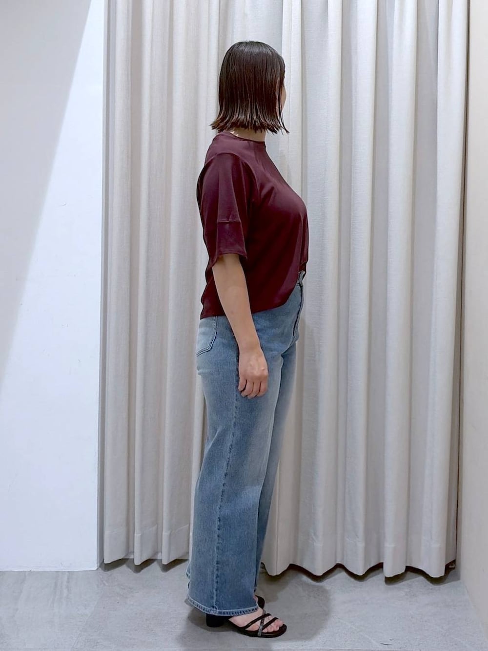 レッド系のTシャツ/カットソー、ブラック系のサンダル、ブルー系のデニムパンツを着用したレディースの夏コーディネートの5枚目の写真