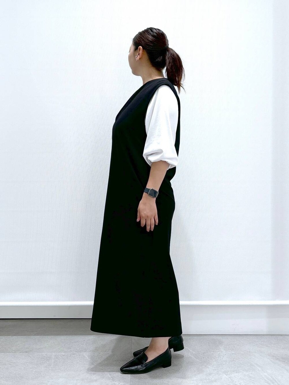 ブラック系のジャンパースカート、ホワイト系のTシャツ/カットソーを着用したレディースの夏コーディネートの3枚目の写真