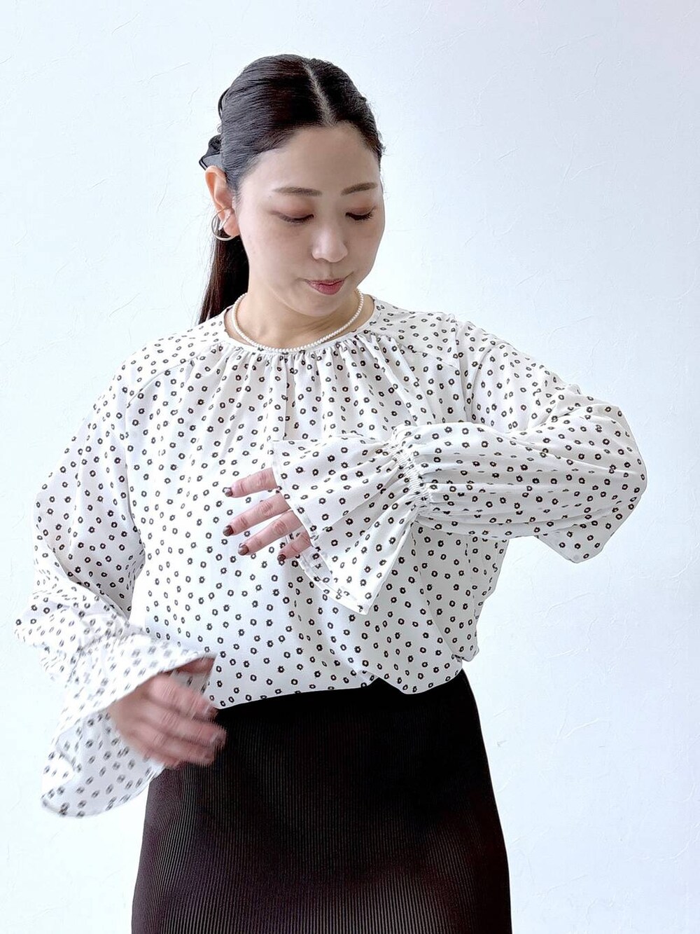 ブラック系のパンプス、ブラック系のトートバッグ、ホワイト系のシャツ/ブラウスを着用したレディースの冬コーディネートの6枚目の写真