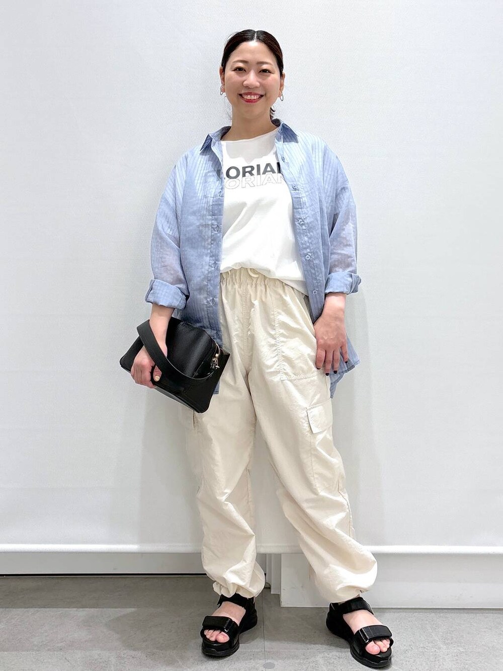 ホワイト系のTシャツ/カットソー、ブラック系のサンダル、ブラック系のハンドバッグを着用したレディースの春コーディネートの2枚目の写真