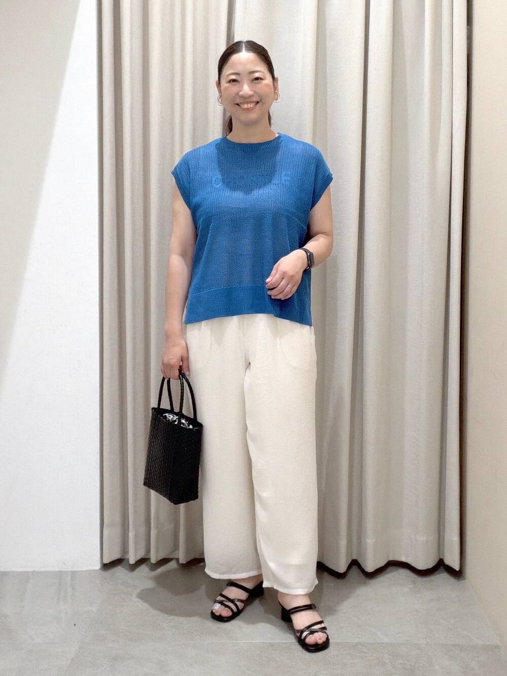 ホワイト系のその他パンツ、ブラック系のサンダル、ブラック系のかごバッグを着用したレディースの夏コーディネートの2枚目の写真