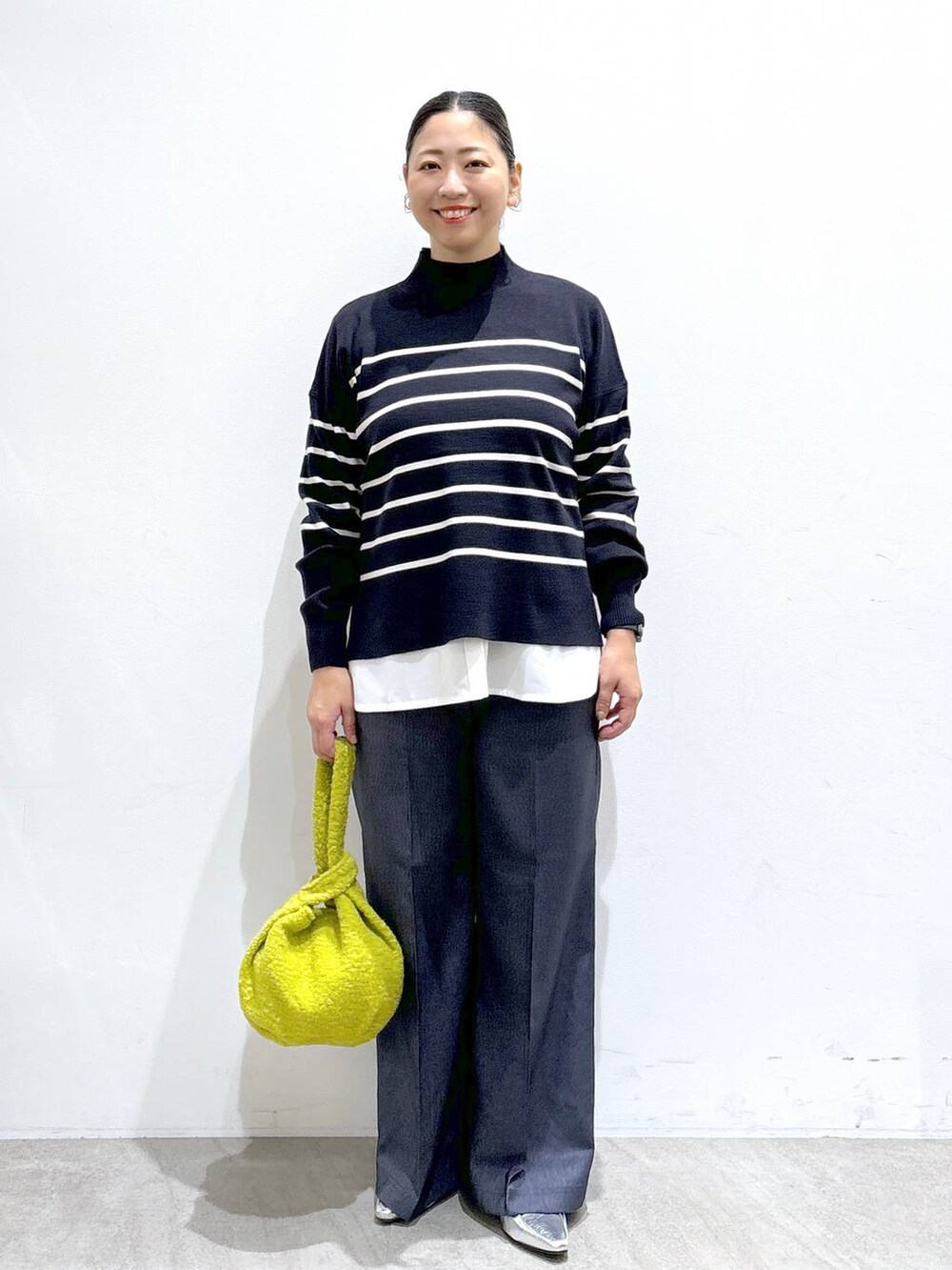 シルバー系のローファー、ブルー系のニット/セーター、ブルー系のデニムパンツを着用したレディースの秋コーディネートの2枚目の写真