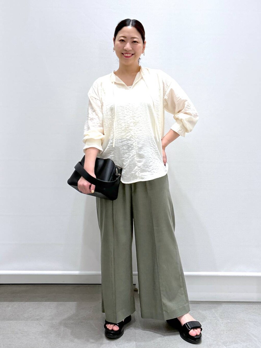 グリーン系のその他パンツ、グリーン系のその他パンツ、ブラック系のハンドバッグを着用したレディースの春コーディネートの2枚目の写真