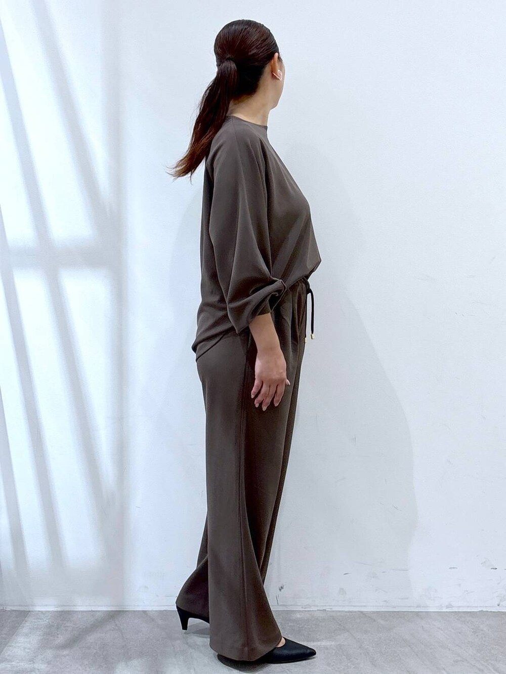 ブラック系のパンプス、ブラウン系のその他パンツ、ブラウン系のTシャツ/カットソーを着用したレディースの秋コーディネートの5枚目の写真