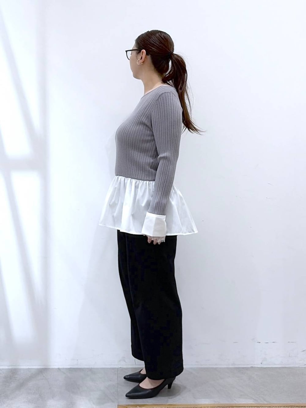 ブラック系のその他パンツ、ブラック系のハンドバッグ、ブルー系のカーディガン/ボレロを着用したレディースの春コーディネートの3枚目の写真