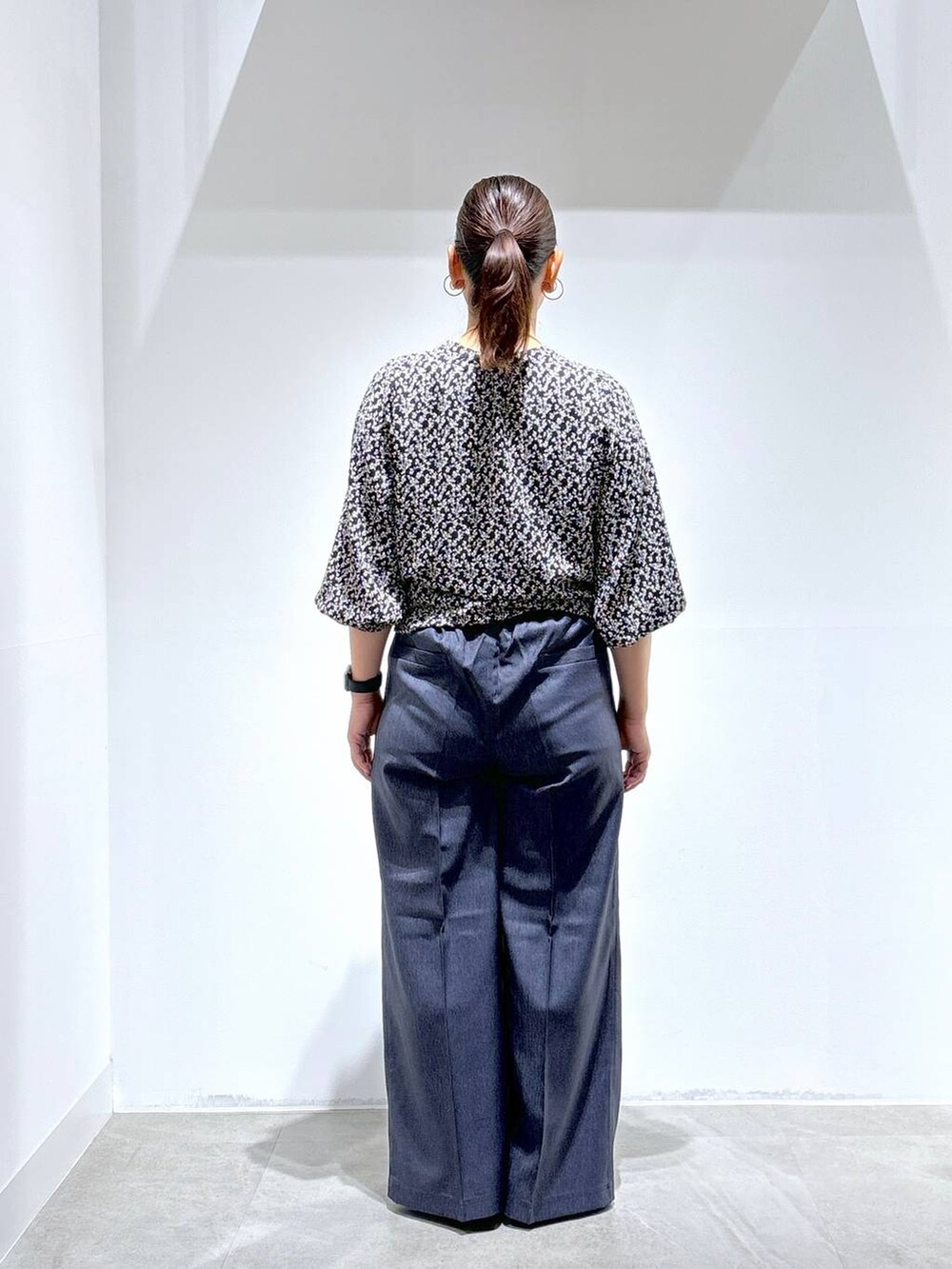 ブラック系のトートバッグ、ブラック系のパンプス、ブルー系のデニムパンツを着用したレディースの秋コーディネートの4枚目の写真