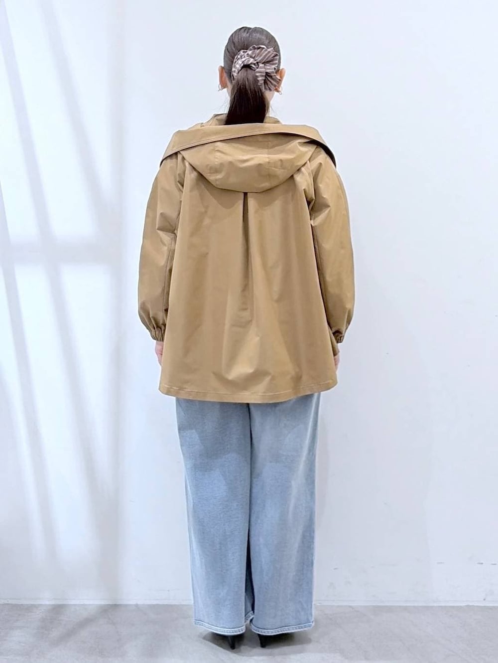 ブラック系のトートバッグ、ホワイト系のニット/セーター、ブルー系のデニムパンツを着用したレディースの春コーディネートの4枚目の写真