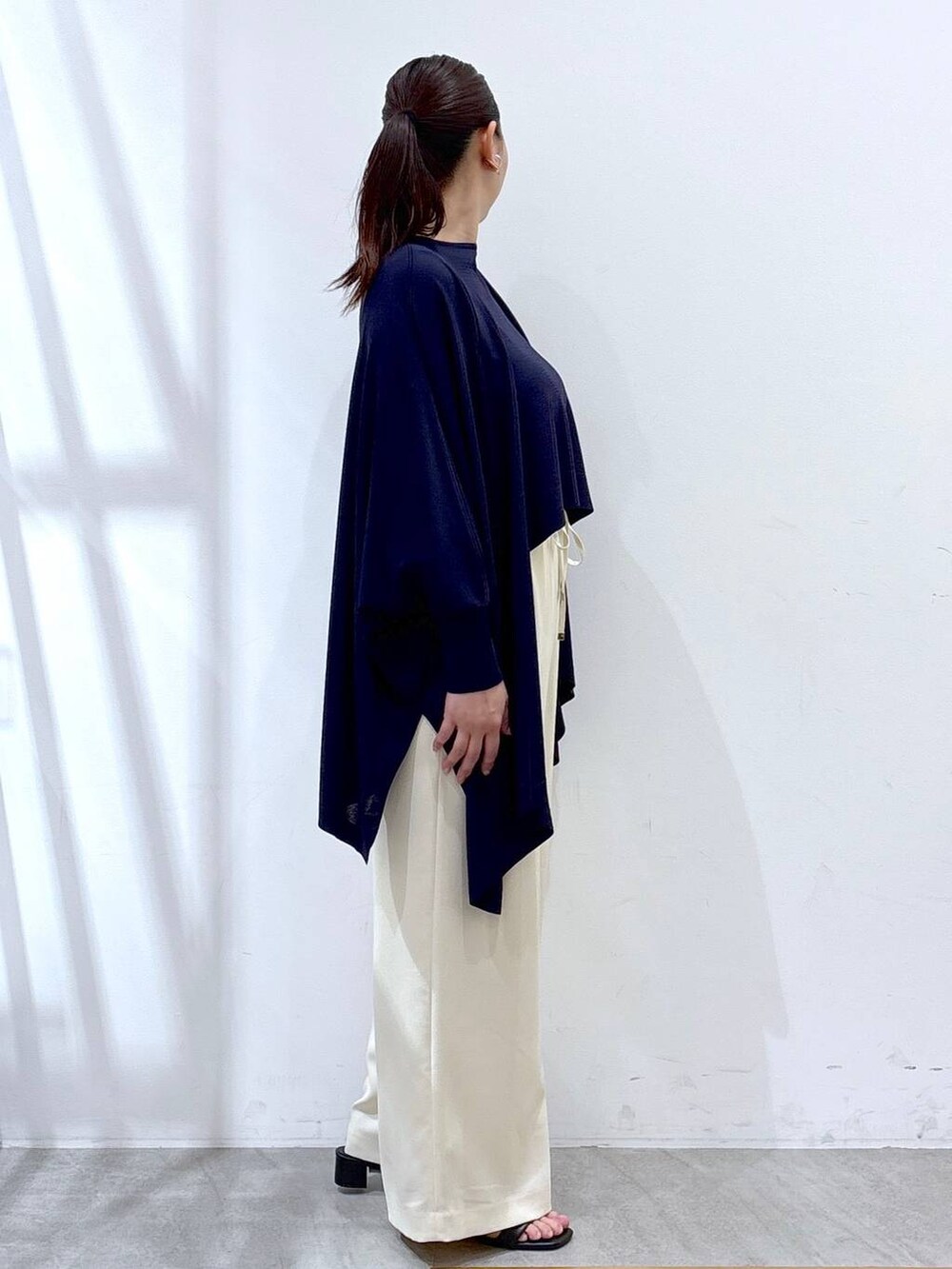 ブルー系のニット/セーター、ブルー系のカーディガン/ボレロ、ホワイト系のその他パンツを着用したレディースの春コーディネートの5枚目の写真