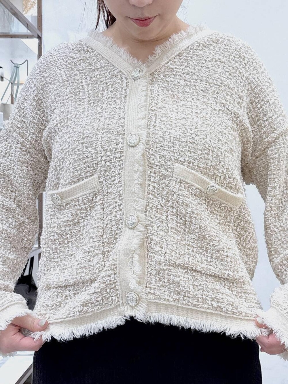 ベージュ系のスカート、ホワイト系のパンプス、ホワイト系のトートバッグを着用したレディースの冬コーディネートの7枚目の写真