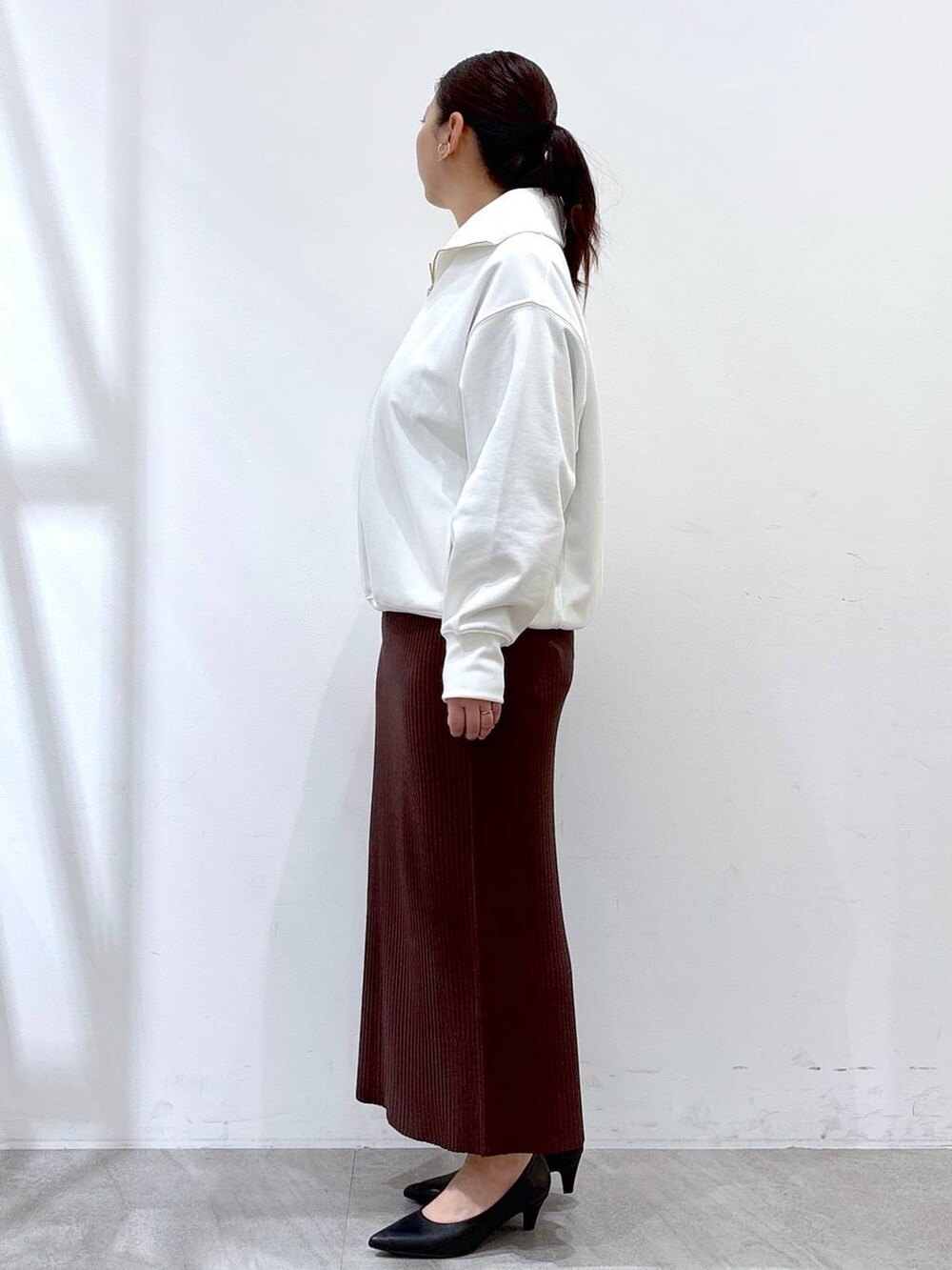ブラウン系のスカート、ホワイト系のTシャツ/カットソーを着用したレディースの春コーディネートの3枚目の写真