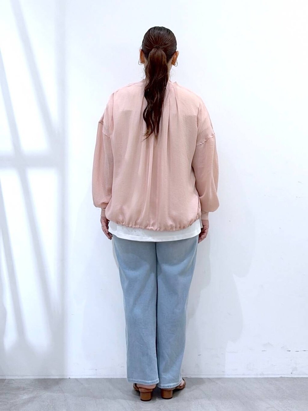 ブラウン系のサンダル、ホワイト系のTシャツ/カットソー、ブルー系のデニムパンツを着用したレディースの夏コーディネートの4枚目の写真