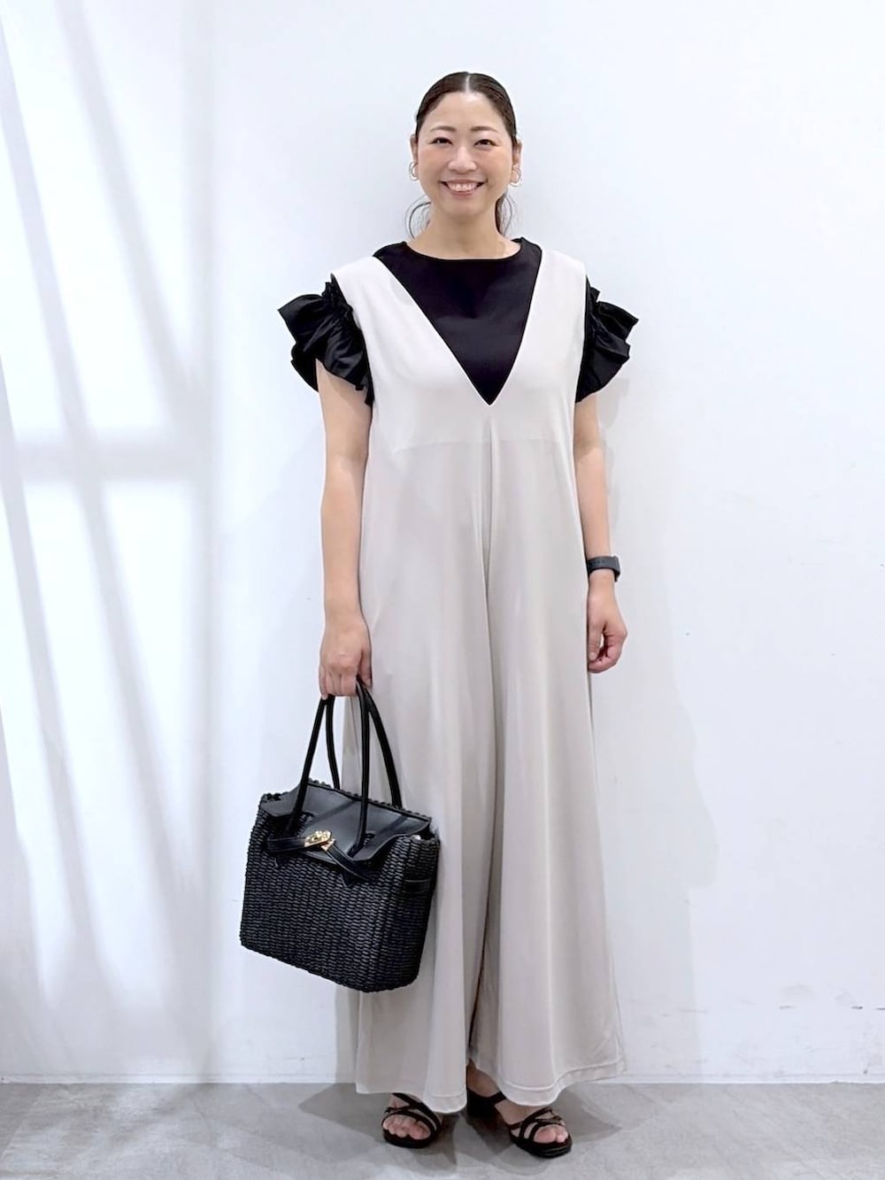 ベージュ系のサロペット/オーバーオール、ブラック系のサンダル、ブラック系のTシャツ/カットソーを着用したレディースの夏コーディネートの2枚目の写真