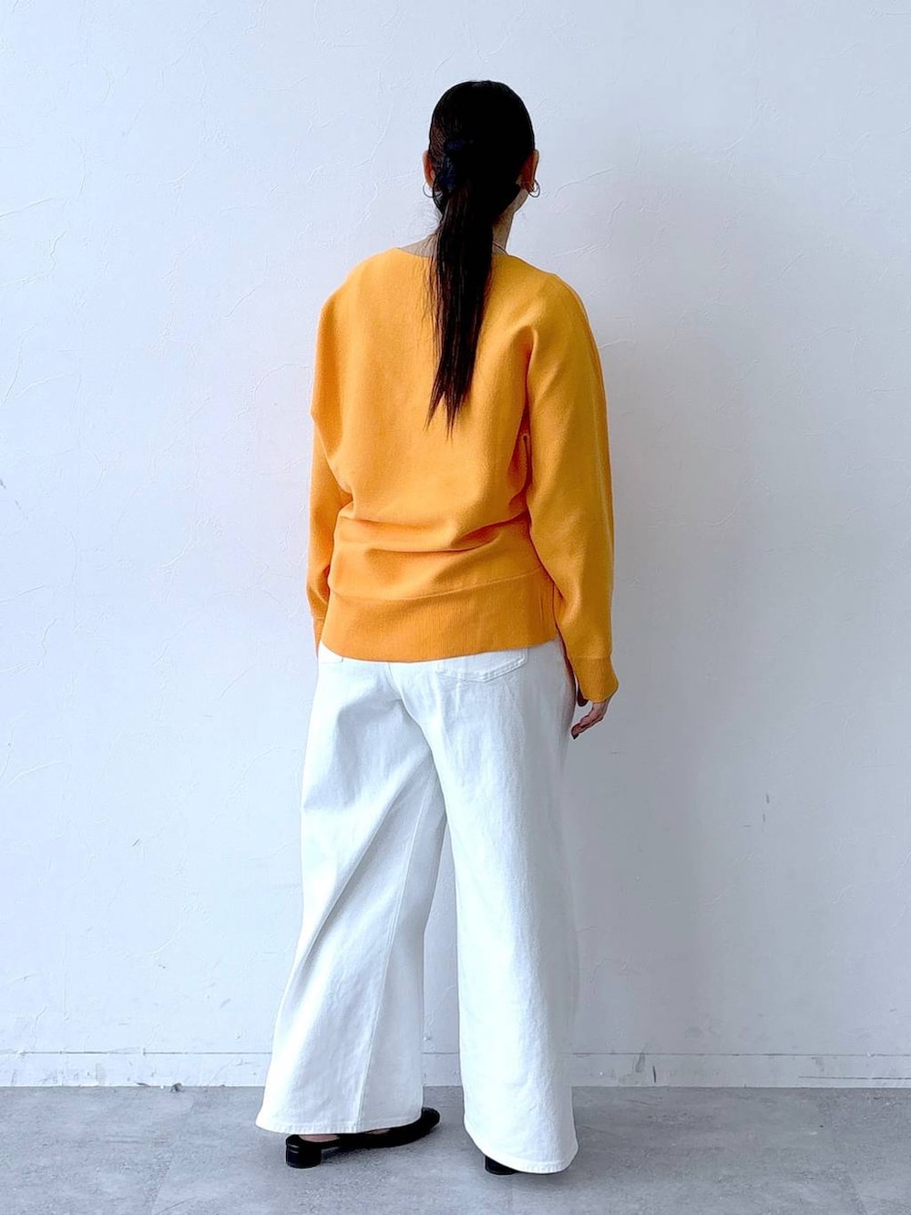 ホワイト系のデニムパンツ、ブラック系のパンプス、ブラック系のトートバッグを着用したレディースの春コーディネートの5枚目の写真