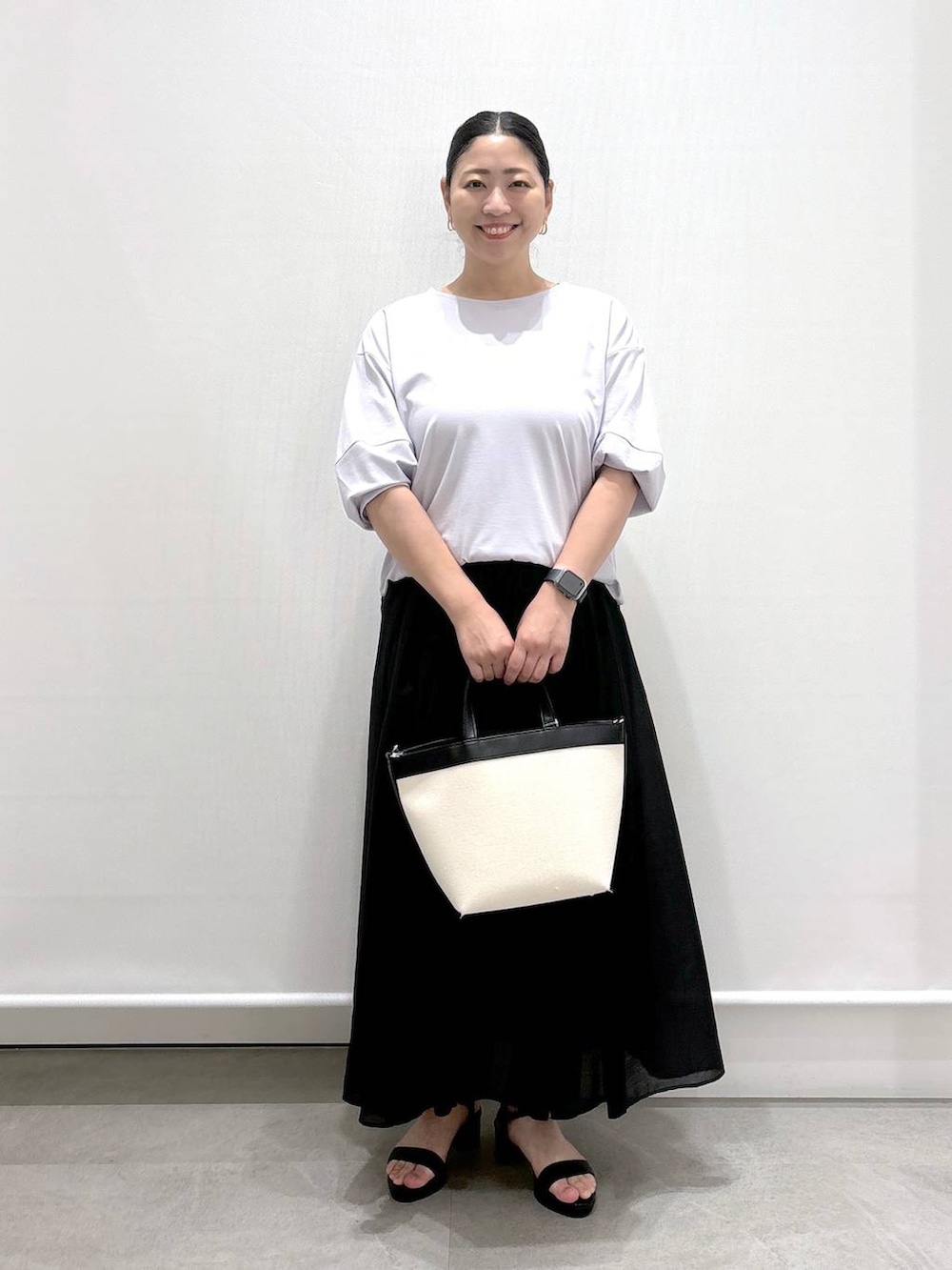 グレー系のTシャツ/カットソー、ブラック系のサンダル、ブラック系のスカートを着用したレディースの夏コーディネートの2枚目の写真