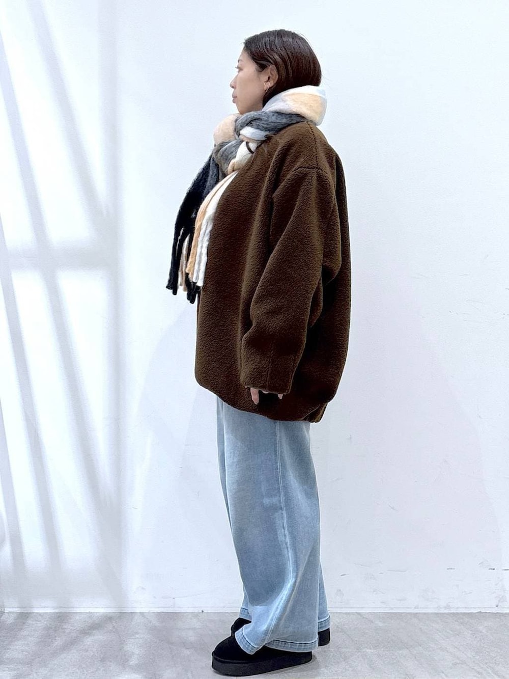 ブラック系のブーツ、ブラック系のボストンバッグ、ブラウン系のブルゾンを着用したレディースの冬コーディネートの3枚目の写真