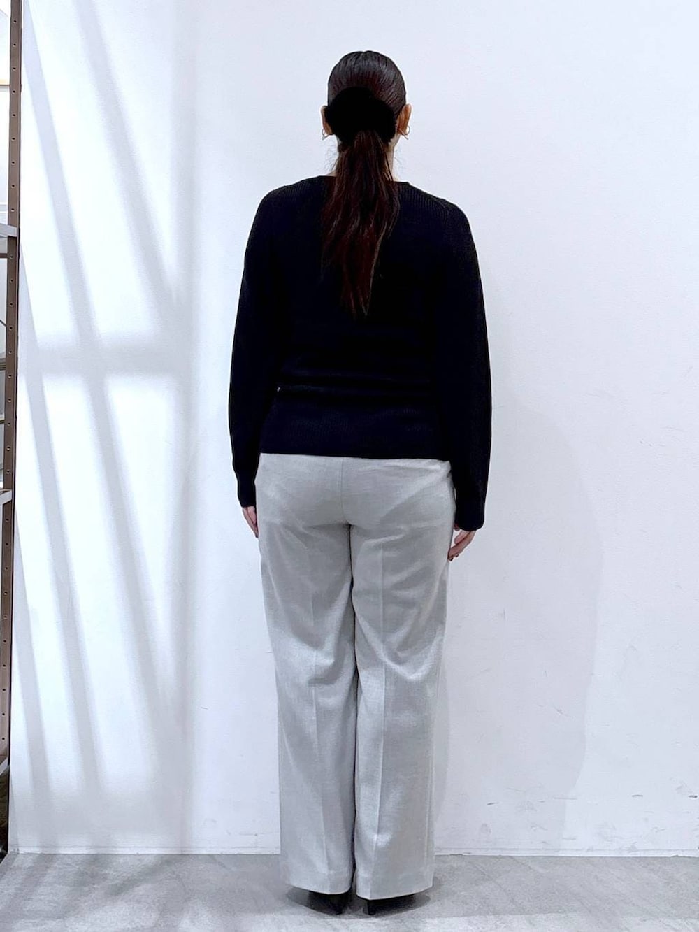 ブラック系のパンプス、グレー系のその他パンツ、ブラック系のカーディガン/ボレロを着用したレディースの冬コーディネートの6枚目の写真