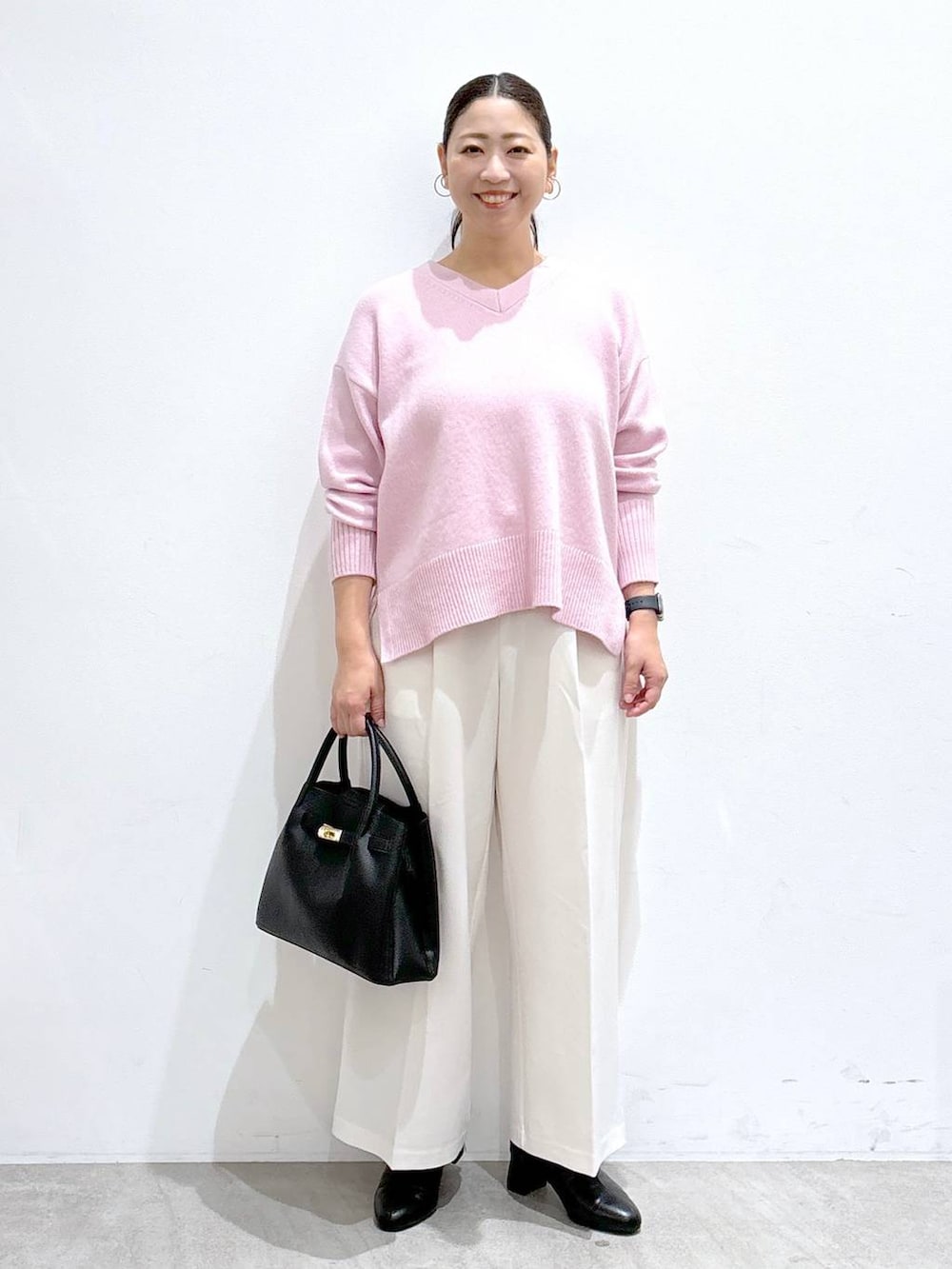 ホワイト系のその他パンツ、ホワイト系のその他パンツ、ブラック系のハンドバッグを着用したレディースの秋コーディネートの2枚目の写真