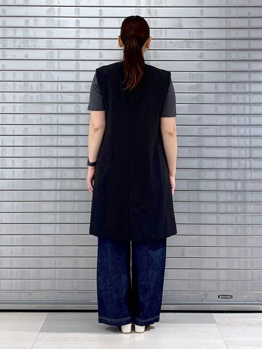 グレー系のTシャツ/カットソー、ブルー系のデニムパンツ、ホワイト系のハンドバッグを着用したレディースの春コーディネートの4枚目の写真