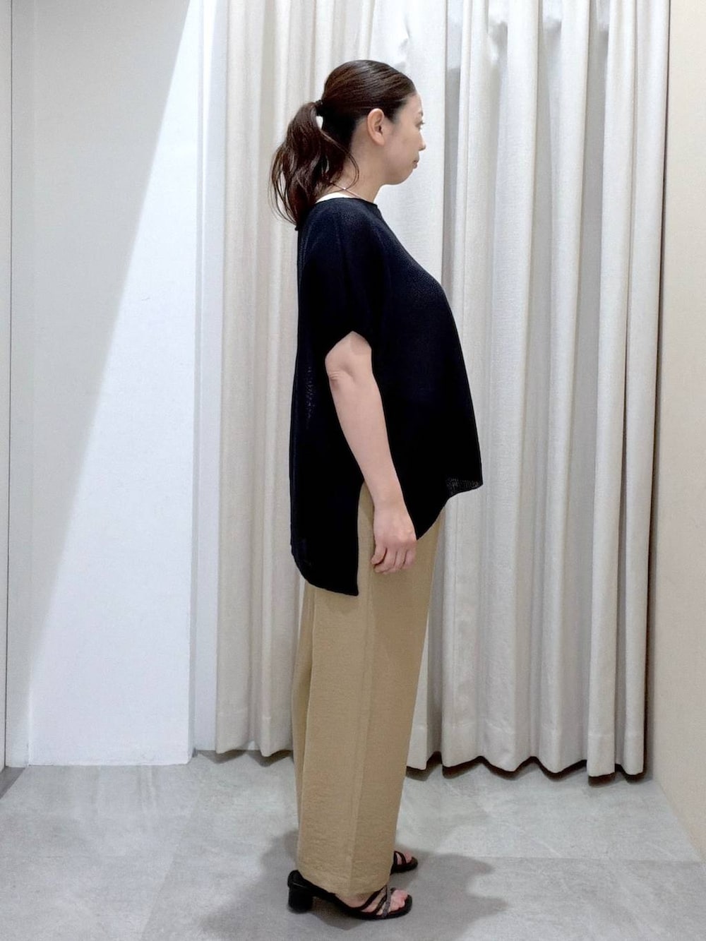 ブラック系のサンダル、ベージュ系のその他パンツ、ブラック系のかごバッグを着用したレディースの夏コーディネートの3枚目の写真